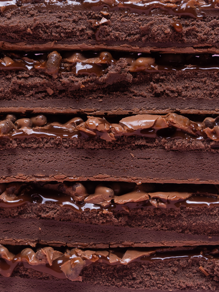 Barebells Chocolate Dough bar cross-section showing chocolate cake layers with chocolate filling and cookie dough pieces