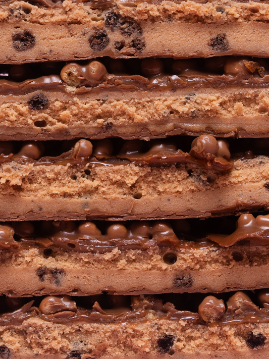 Barebells Cookies Caramel bar cross-section showing cookie layers with caramel filling and chocolate pieces
