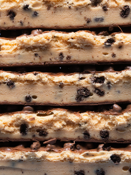 Barebells Cookies and Cream protein bars stacked showing layers of cookie pieces and cream filling
