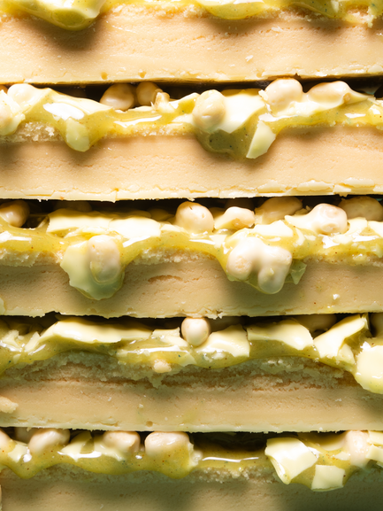 Barebells Key Lime Pie protein bars stacked showing layers of key lime filling, white chocolate pieces and graham cracker base
