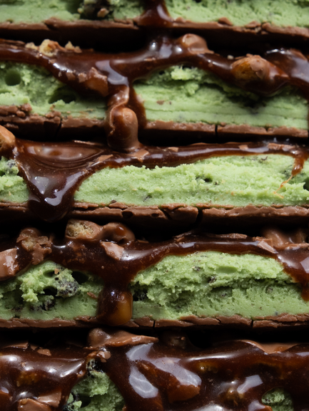 Barebells Mint Chocolate Crisp bars stacked showing green mint filling with chocolate coating and crispy pieces