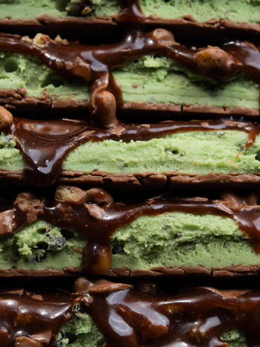 Barebells Mint Chocolate Crisp bars stacked showing green mint filling with chocolate coating and crispy pieces