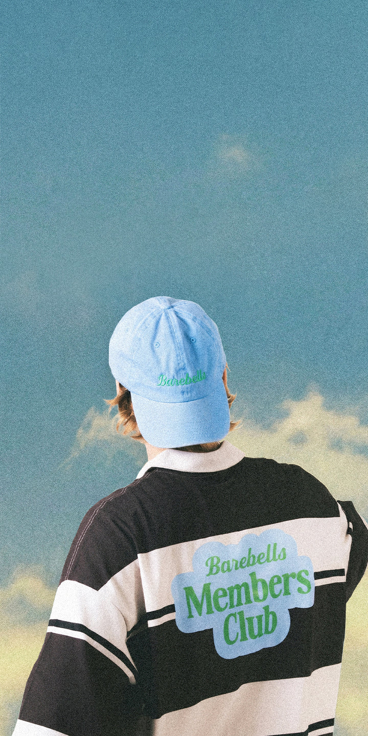 Barebells Members Club Blue Sky Background behind guy with members club logo shirt